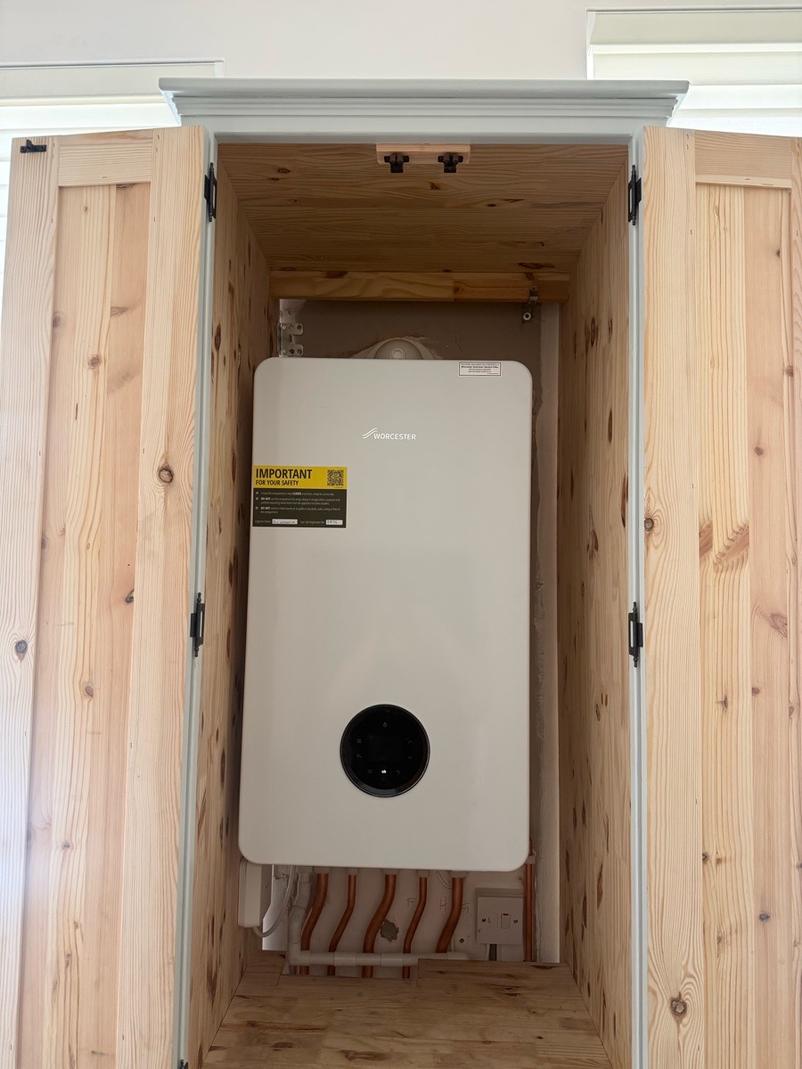 Worcester boiler installed in a bespoke pine cupboard with tidy copper pipework