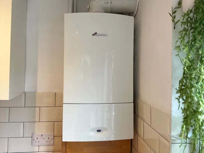 New boiler fitted in a bright room with metro tiles and a wood floor