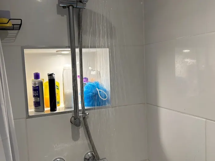 Finished shower with riser rail and a tiled recessed niche