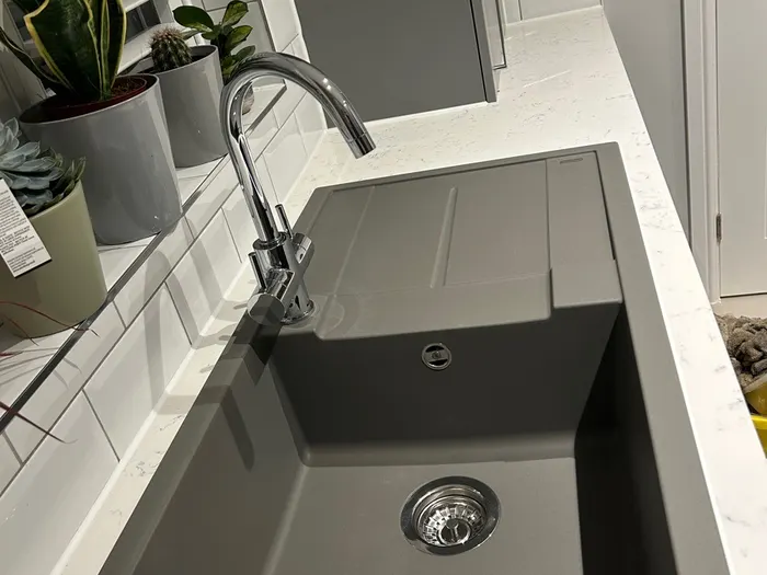 Modern kitchen sink and tall chrome mixer tap