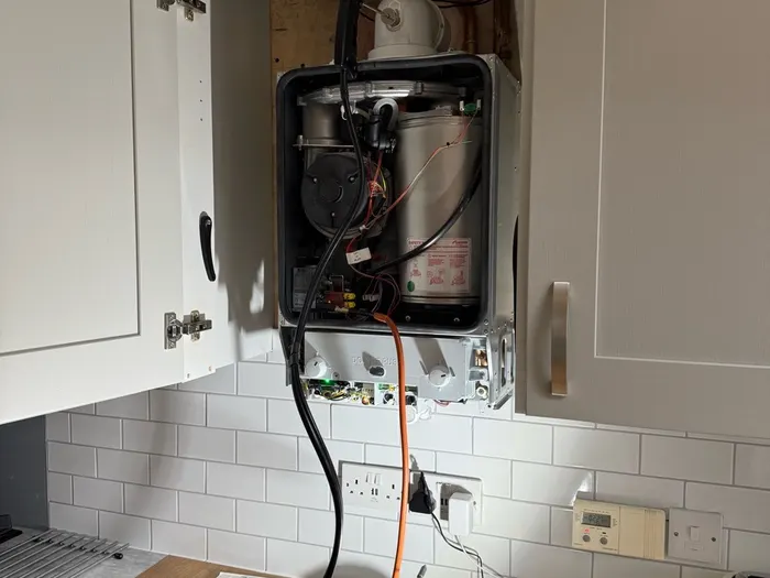 Boiler casing removed during a repair, with tools on the worktop below