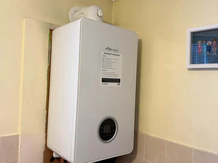 Boiler on a decorated wall with a tiled dado and wood flooring