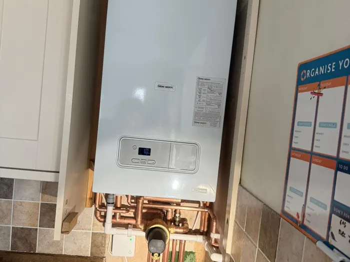 Boiler above a tiled splashback in a utility room